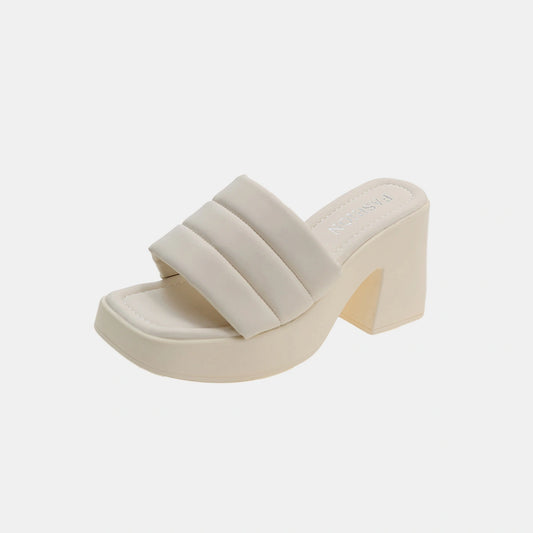 Beige sandal with a block heel on a light gray background