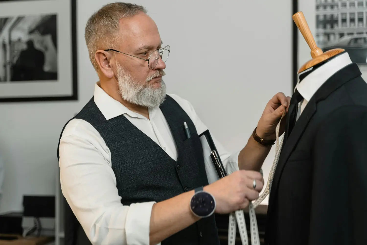 A skilled tailor in a workshop adjusting a classic suit on a mannequin with precision.